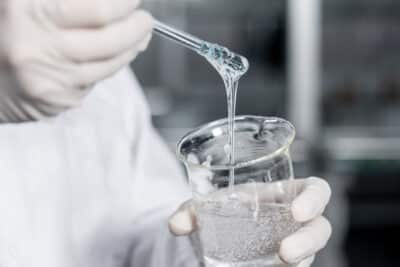 Glue being pulled out from a beaker in a lab